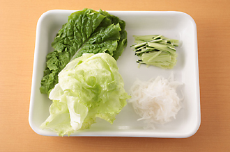 野菜の準備をする。サンチュ、レタスは洗い、レタスは食べやすい大きさにちぎる。きゅうりは長さ5センチくらいの細切りにする。大根も皮をむいて長さ5センチくらいのせん切りにし、塩少々をふって軽くもみ、水気をしぼる。