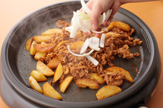 ホットプレートのすき間をあけて、下味をつけた豚肉をつけ汁ごとのせて炒める。肉の色が変わったら玉ねぎを加えて炒め合わせ、全体がなじんだら、仕上げににらを加えてサッと混ぜ、白すりごまをふる。