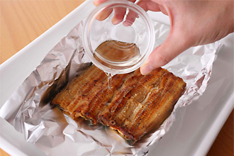うなぎは長さを半分に切り、アルミホイルにのせて酒をふる。魚焼き用グリルを予熱しておく。万能ねぎは小口切り、三つ葉はざく切りにする。