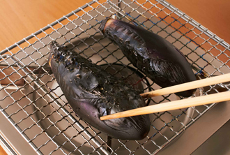 なすは、がくを取って熱した焼き網にのせ、中火で全体が黒く焦げるまで焼く。