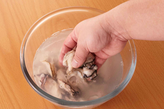 かきはボウルに入れ、たっぷりの水の中でかるく混ぜるようにして洗う。水をとりかえ、汚れが出なくなるまで洗う。