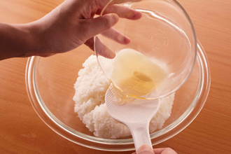 すし酢の材料を混ぜ合わせる。温かいご飯をボウルに入れてすし酢の1/2量を回しかけ、しゃもじで切るように混ぜる。野沢菜漬けの茎をみじん切りにして混ぜ、濡れふきんをかけておく。