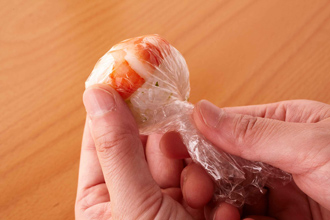 ラップにえびをのせてわさびを塗り、すし飯適量（ピンポン玉くらい）をのせる。ラップで包み、茶巾絞りの要領でひねって丸く形をととのえる。残りの具材も同様にして合計20個作る。野沢菜漬けの葉の場合は葉を広げてすし飯を包むようにして。