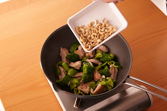 フライパンにサラダ油を中火で熱し、鶏肉を炒める。肉の色が変わったらピーマン、ブロッコリー、カシューナッツを加えて炒め合わせる。