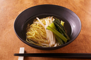 鍋の煮汁には塩豚のうまみがたっぷり入った煮汁を生かして、しめはラーメンに。　塩、こしょうなどで味をととのえ、ゆでたラーメンを加えましょう。