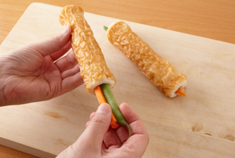 ちくわの野菜詰めを作る。さやいんげんは筋を取る。ちくわにいんげん、にんじんを等分に詰めて長さを半分に切り、さらに斜め切りで半分に切る（合計4個できる）。