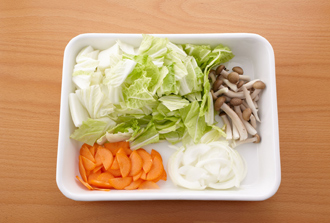 白菜は3センチ四方に切る。にんじんは皮をむいて縦半分に切り、さらに薄切りにする。しめじは根元を切って小房に分ける。玉ねぎは薄切りにする。鶏肉は一口大に切って塩、黒こしょう各少々をふる。