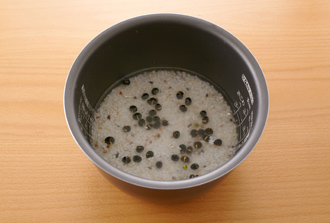 炊飯器に米を入れて目盛り通りに水を入れ、黒豆、雑穀、水大さじ2を加えて普通に炊く。