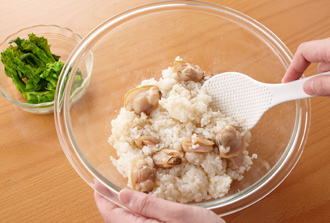 ボウルに温かいご飯、はまぐりの身と汁を入れ、塩をふって混ぜる。菜の花も加えて混ぜ、器に盛る。