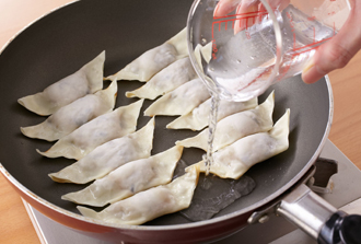 フライパンにサラダ油を薄くひき、餃子を並べて強めの中火にかける。焼き色がついたら水を回し入れてふたをし、水気がなくなるまで蒸し焼きにする。ひっくり返してもう片面にもこんがりと焼き色がついたら、皿に盛る。タレを作り、ざく切りにした香菜とともに添え、好みでつけて食べる。