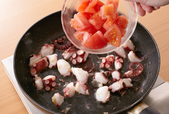 フライパンにオリーブ油、にんにくを入れ、弱火にかけて炒める。にんにくの香りが出て色づいてきたらたこを加え、中火で炒める。油がなじんだらトマトを加えてサッと炒める。