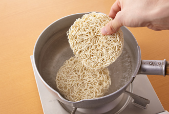 鍋に分量の水を入れて火にかけ、沸騰したら麺を1分30秒ほどゆで（袋の表示時間の半分くらい。固めにゆでる）、麺を取り出す（ゆで汁はとっておく）。キャベツは2センチ角に切り、ねぎは幅1センチの斜め切りにする。