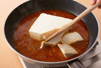 酒、水を加え、煮立ったら豆腐を切らずに加えて、食べやすい大きさにくずす。