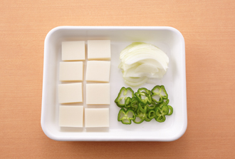 切り餅は半分に切る。玉ねぎは薄切りにする。ピーマンはへたと種を取って輪切りにする。