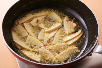 フライパンにオリーブ油、にんにく、赤唐辛子、たけのこを入れて弱火で熱し、にんにくが色づくまで炒める。