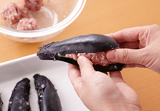 なすの水気を拭き、切り込みの内側に薄力粉を薄くまぶす。ひき肉だねの1/4量ずつはさんで形を整え、全体にも薄力粉をまぶす。