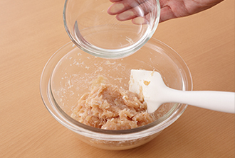 ボウルに水以外の鶏団子のたねの材料を入れ、粘りが出るまで練ったら、水を少しずつ加えながらよく混ぜる。