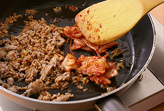 にらは長さ4センチに切っておく。フライパンにごま油大さじ1/2を中火で熱し、ひき肉を炒める。肉の色が変わったら豆板醤、にんにく、しょうがを加えて香りが出るまで炒める。白菜キムチを加えてさらに1分ほど炒める。