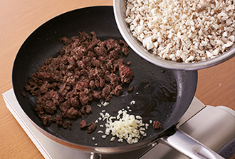 ミートソースを作る。フライパンを強火で熱し、ひき肉を入れてほぐしながら強火で炒め（肉から脂が出るので油はひかなくてよい）、肉の色が変わったらにんにく、しめじ、えのきだけを加える。塩をふって2分ほど炒めたらAを加えて2分ほど煮る。