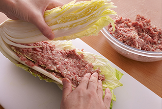 白菜の葉と葉の間に、ひき肉だねを塗るようにのせ、はさんでいく。