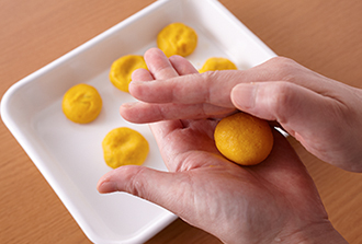 レンジ加熱したかぼちゃをボウルに入れ、木べらなどでなめらかになるまでつぶす。薄力粉を加えてよく混ぜ、10等分にして丸め、指で少しつぶして平らにする。