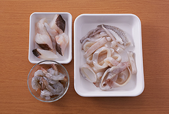 いかは内臓を取り出してよく洗い、水気をきる。胴は幅1センチの輪切りにし、足は食べやすい大きさに切る。たらは3等分に切って骨を取る。えびは尾を残して殻をむき、背に切り込みを入れて背わたを取る。