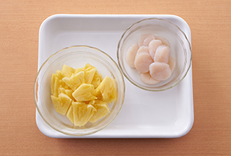 パイナップルは食べやすい大きさの薄切りにする。帆立貝柱は厚みを半分にスライスする。