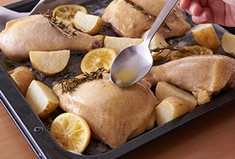 オーブンを200度に予熱する。天板にオーブン用シートを敷き、鶏肉の皮目を上にして並べ、じゃがいもとレモンは鶏肉の周りに並べる。残ったマリネ液を鶏肉にかけ、オーブンで20分焼いていったん取り出す。オーブン温度を220度に上げる。天板の肉汁をスプーンで鶏肉にかけて、さらに10～15分鶏肉の皮がパリッとするまで焼く。途中、じゃがいもに火が通ったら先に取り出す。皿に盛り、クレソンと飾り用のローズマリーを添える。