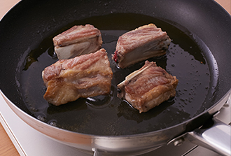 フライパンにサラダ油を入れ中火で熱し、スペアリブをこんがりと焼いていったん取り出す。