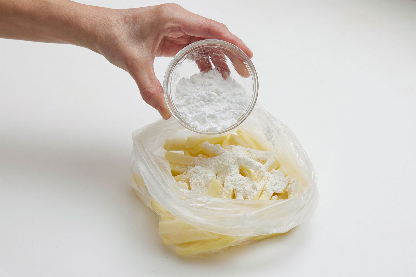 袋に小麦粉、片栗粉を入れて水切りをしたじゃがいもを加え空気を入れて膨らませ、シャカシャカとふって粉をまぶす。