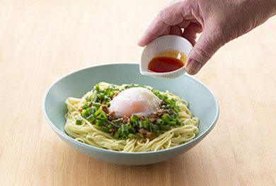 中華そばを器に盛り、肉味噌、万能ネギ、温泉卵をのせラー油をかける。